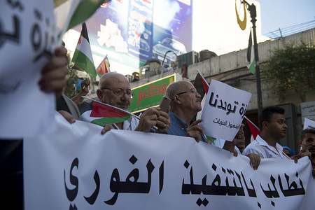 People seen holding a huge banner during the rally.
Thousands of demonstrators protest against the Palestinian Authority gathered in Manara Square and marched to Arafat Square to show solidarity with Gaza.