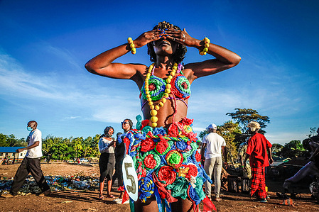 A young female model dressed in a colorful outfit poses by the streets during the Mr. and Mrs. Kibera, a modeling contest in Kibera Slums.
Young models and artists from the Kibera slum attend Mr. and Mrs. Kibera, a modeling contest, where the contestants wear beautiful, African outfits. The fashion contest organized by Amani Kibera takes place each year with a mission to identify the king and queen of beauty and fashion in the slums.