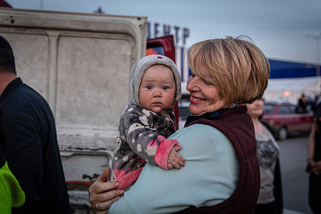 A mother holds her baby as they arrived from Mariupol in Zaporizhia. According to the United Nations, more than 11 million people have fled their homes in Ukraine since the conflict began, with 7.7 million people displaced inside their homeland.