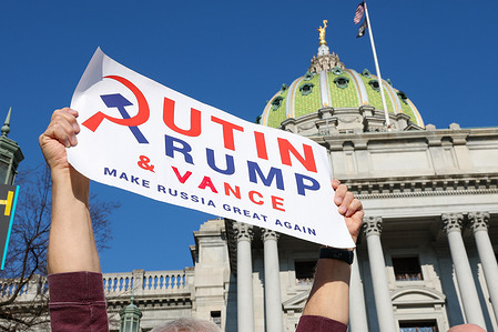 An anti-Trump protester holds a placard outside of the Pennsylvania State Capitol. Protesters gathered across the United States as part of the 50501 movement, a grassroots political activist initiative organizing nationwide demonstrations. The movement's name, "50 protests, 50 states, 1 day," reflects its aim to hold coordinated protests simultaneously across all states. Participants opposed policies of the Donald Trump administration, raised concerns about democratic institutions, advocated for LGBTQ+ and immigrant rights, and protested Elon Musk’s involvement in government.