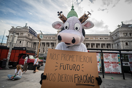 A protester dressed as cow holds a placard that says They promised us a future, they gave us fracking during the demonstration.
Several environmental organizations held a rally to raise awareness about climate change on world water day.