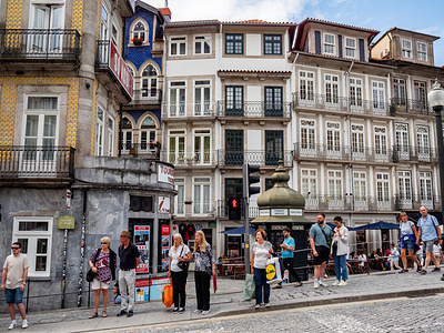 Tourists are seen waiting to cross one of the busiest streets in the city. Porto is Portugal's second-largest city and is the capital of the Northern region, and a busy industrial and commercial center. The city is built on the high ground overlooking the Douro River estuary's northern side, and its historical center was declared a UNESCO World Heritage Site in 1996.