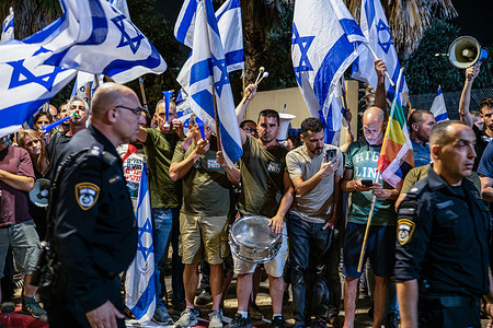 Protesters hold Israel flags in front of Hadera police station during the demonstration. Israeli police officers push back protesters against the judicial reform who demonstrated in front of Hadera police station in support of protesters who were arrested next to Prime Minister Benjamin Netanyahu’s house in Caesarea.