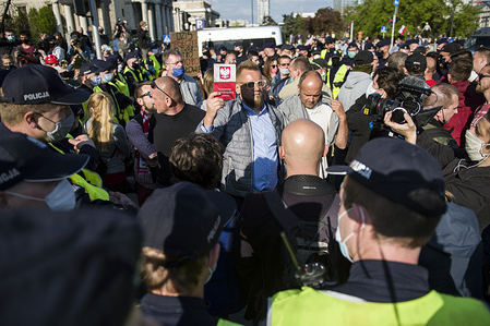 Pawel Tanajno holding the Polish Constitution during the demonstration.
The group called "Entrepreneurs' Strike" led by the presidential candidate, Pawel Tanajno gathered to protest for the second day in a raw against the "freezing of the economy" due to the pandemic of corona virus. Protesters blocked the traffic in Warsaw's centre. Numerous protesters were arrested during the strike.