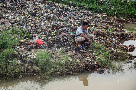 A man is seen fishing on a riverbank piled with garbage after the floods in Jakarta.Heavy flooding caused piles of garbage on the banks of Ciliwung river which is a livelihood for many fishermen.