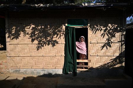 Sura Khatun poses for a photo in front of her bamboo-shelter inside the camp. This is all she knows as her home for the last few years.