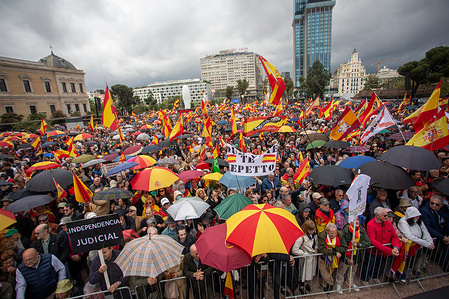 Protesters raise banners and flags at a demonstration. Demonstration organized by the Platform for Constitutional Spain with the slogan "For the dignity of Spain. Sánchez resigns, elections now" held in Madrid's Plaza de Colón.