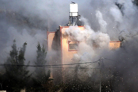 Smoke rises from a Palestinian home after it was demolished by the Israeli army with explosives. Israeli army demolished the home of a Palestinian accused of carrying out an armed attack that killed an Israeli soldier and a Jewish settler in the village of Tell.