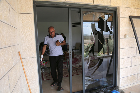 A Palestinian man inspects his damaged home in the Masoudiya area. Jewish settlers attacked Palestinian homes throwing stones and setting fire to farmland on the village of Deir Dibwan and the Masoudiya area. Palestinians reported that ten people were injured in the settler attacks.
