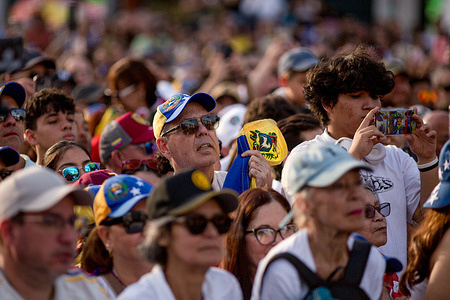 A man holds a Venezuelan flag as María Corina Machado, Nobel Peace Prize laureate and leader of the Venezuelan opposition, greets and addresses the Venezuelan diaspora in Madrid's Puerta del Sol.