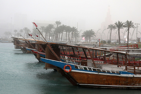 Traditional boats are moored at sea along the Corniche during a sandstorm hitting Doha, Qatar.