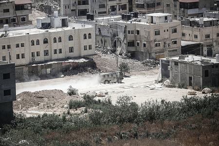 An Israeli military vehicle patrols the streets of Nur Shams refugee camp. Israeli army bulldozers demolished 48 Palestinian homes and destroyed infrastructure. And14,000 people were displaced from their homes during Operation Iron Walls on refugee camps in the West Bank.
