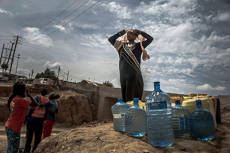 A woman stands next to her water containers and water bottles filled with water during the water shortage in Nairobi.
Most Nairobi residents continue to experience the day-to-day shortage and lack of water. In Kibera Slums, the Nairobi Metropolitan Services (N.M.S) has taken in their hands the responsibility of providing most residents within some poor communities with access to free and frequent clean water services.