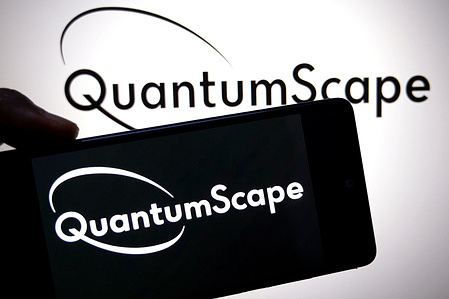 In this photo illustration, a QuantumScape logo is seen displayed on a smartphone and in the background.