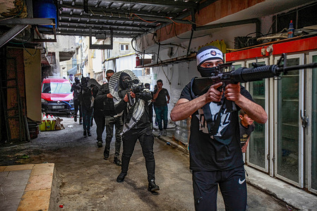 Palestinian gunmen from the Balata Brigade take part during the parade, in the Balata refugee camp, east of Nablus, in the occupied West Bank. Many Palestinian armed battalions including the Lions' Den, the Al-Aqsa Martyrs Brigades and the Balata Brigade paraded in the Balata refugee camp.