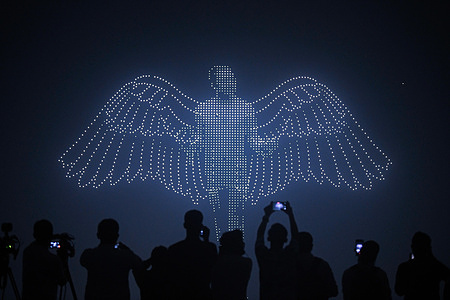 A colorful drone show lights up the sky over the National Parliament building on Pahela Baishakh displaying the message ìMessenger of Peaceî as people capture the moment on their mobile phones.