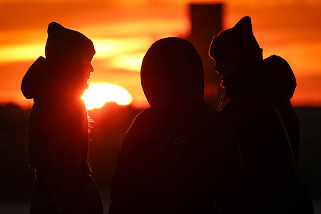 Silhouettes of people seen during sunset.