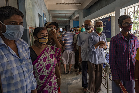 People wearing face masks as a preventive measure against the spread of covid-19 wait to be vaccinated at the Madhyamgram Rural Hospital in Kolkata.
India is facing a worst hit by the second wave of COVID-19 as daily case count crossed over 16.6 Millions cases in the country in total and over 2600 death per day as per media reports, the world's largest one-day rise in coronavirus cases.