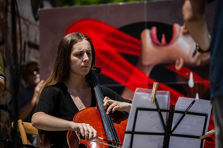 A woman plays the violin during a pro-Palestinian demonstration. Rally at the Reina Sofia Museum in Madrid. National Day of Action for the End of Genocide, "for a just peace, a definitive ceasefire, neither terrorism nor genocide," called by the Stop the War Now platform.