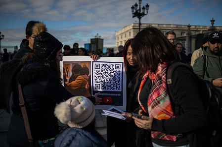 Female followers of religious leader Abdullah Hashem show a woman a QR code with information. During a gathering of followers of Abdullah Hashem Aba al-Sadiq, an Egyptian-American religious leader and founder of the Ahmadiyya Religion of Peace and Light (AROPL), who claims to be the successor of Jesus, Saint Peter, Muhammad, the Mahdi, Ahmed al-Hasan, and the only true and legitimate pope.
