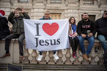 A devout Christian holds a religious flag during the Christmas service outside the Downing Street. Far-right protesters gathered for the Tommy Robinson's Christmas service outside Downing Street in London. Stephen Christopher Yaxley-Lennon better known Tommy Robinson is one of the most prominent far-right activists in the UK. He was the founder of the English Defence League and the British National Party.
