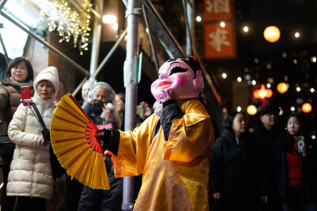 A performer dressed as a monk waves a fan during the Midnight Madness Lunar New Year celebration in the Chinatown neighborhood of Manhattan, New York. Midnight Madness is a local tradition where dancers wearing lion costumes perform at midnight, ushering in Year of the Horse.