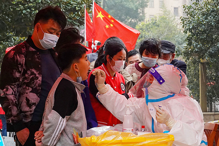 A community COVID-19 control worker performs nucleic acid testing on a community resident in Changzhou. A total of 17 COVID-19 positive cases have been screened in Changzhou, China. As of March 14, 2022, there were 242,703 confirmed cases in China, including 227,451 in Hong Kong.