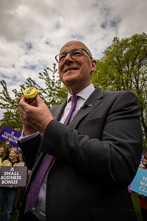 First Minister of Scotland, John Swinney seen posing for a photograph with a small cake iced in the colours of the Scottish National Party (SNP). On the afternoon of Wednesday the 6th of May, leader of the Scottish National Party (SNP) and First Minister of Scotland, John Swinney addresses candidates and activists who have been taking the SNP message across Scotland for the past six weeks of the Scottish parliamentary election campaign. The First Minister gives a short eve-of-poll speech before campaigning with the SNP candidates.