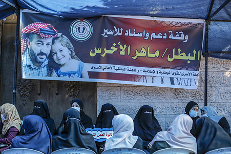 Protesters sit next to a banner with images of Maher Al-Akhras and his daughter, during the demonstration.
Solidarity protest with Maher Al-Akhras, 49, a Palestinian jailed by Israel, who has been on hunger strike for 84 days, protesting his detention without trial.