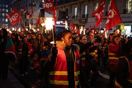 A woman marches with a torchlight during the demonstration. Around 300 people joined a torchlight march in Paris organized by the General Confederation of Labour (CGT) and the Services Union to demand higher wages, better working conditions, and the maintenance or reinstatement of the retirement age at 60. The demonstration also protested the French government’s austerity budget.