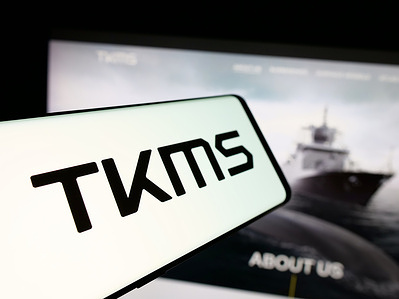 In this photo illustration, a smartphone with the logo of company ThyssenKrupp Marine Systems (TKMS) is seen on screen in front of website.