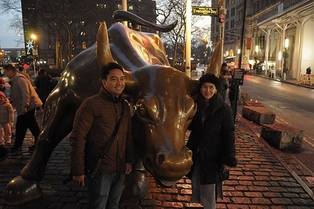People take photos by the "Charging Bull" statue in the Financial District in Manhattan, New York City.