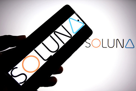 In this photo illustration, a Soluna logo is seen displayed on a smartphone and in the background.