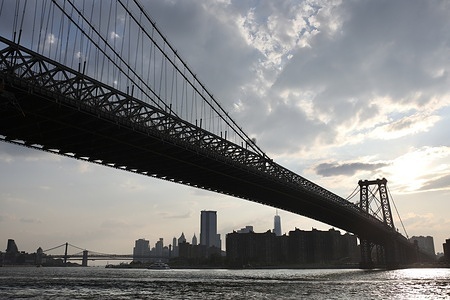 Downtown Manhattan, the Manhattan bridge and the Brooklyn Bridge in New York are seen at night from Domino's Park.
