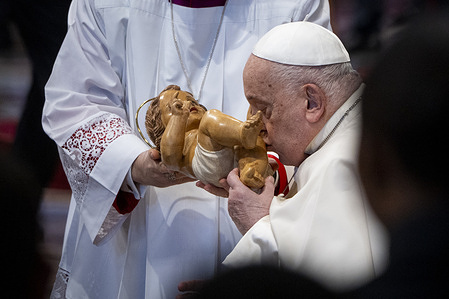 Pope Francis kisses the statue of baby Jesus during the Mass on the Solemnity of the Epiphany of the Lord.