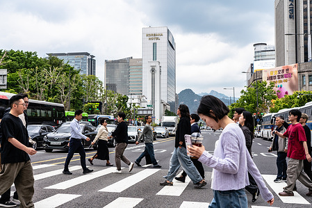 People cross the road in Seoul.