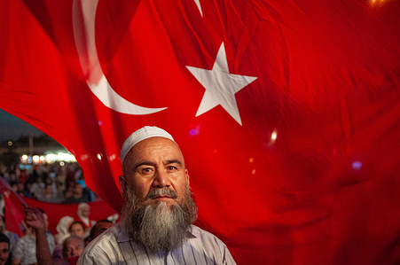 A Turkish man and national flag among the crowds that fill Taksim Square in Istanbul to celebrate the failure of attempted coup d’état against the Akp ruling government of Recep Tayyip Erdogan.