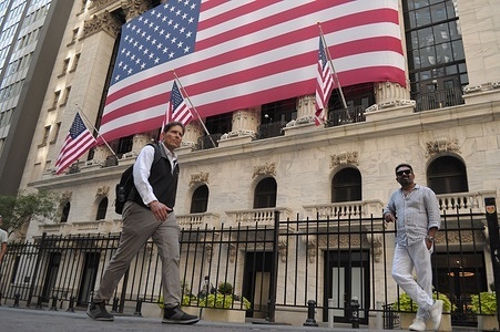 People walk past the New York Stock Exchange in the Financial District in Manhattan, New York City.