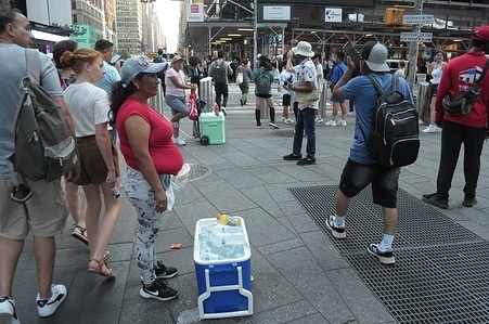 A person sells beverages on the street during the third heat wave of the summer in Manhattan, New York City. New Yorkers are experiencing high temperatures in the 90s with humid weather making the weather feel hotter. Weather advisories are urging people to stay cool and hydrated amid the hot weather.