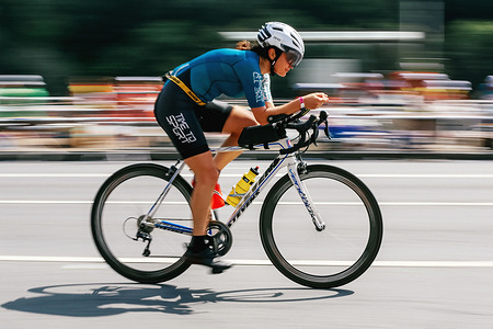 Female Triathlete seen passing cycling stage at the Moscow Ironman 226.
at Frunzenskaya embankment. Natalia Agafonova on cycling stage. Moscow Ironman 226 and Russian Triathlon Championship brings together more than 11,000 athletes from 10 countries and about 70,000 funs. Swimming stage was organized at the Krylatskoye Rowing Canal and running and cycling stages at the Luzhniki Open Stadium.