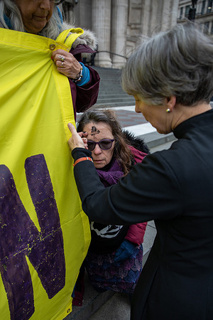 A Christian protestor has a black ash cross painted on her forehead during a Fossil Free London demonstration. Christian protesters from Fossil Free London held a die-in at St Paul’s Cathedral, displaying banners against the Rosebank oil field and urging the Church to oppose it. The demonstration, marked by a funeral-like mood with tombstones and a roll call of death causes, lasted 10–15 minutes. Some participants received ash crosses on their foreheads using symbolic oil.