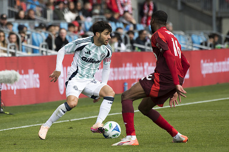 Tyrese Spicer #16 (R) and Carles Gil #10 (L) in action during the MLS game between Toronto FC and New England Revolution at BMO field in Toronto. New England Revolution 2-0 Toronto FC