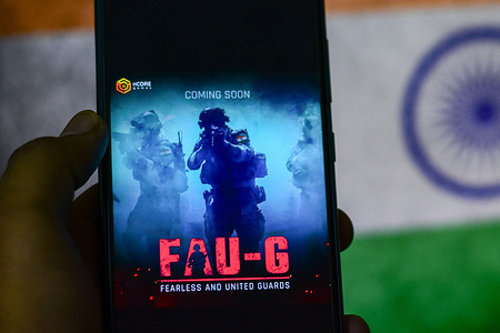 In this photo illustration an upcoming FAU-G app game icon seen displayed on a smartphone with the Indian flag in the background.
