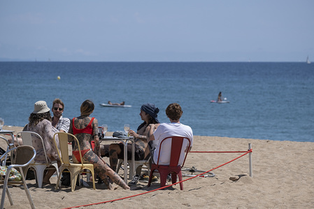 A group of people on a terrace of one of the chiriguitos on the Barceloneta beach during Phase 1.
First beach weekend with the terraces of the bars and restaurants open to the public under Phase 1 of the Covid-19. Laying on the beach sand or recreational bathing is still unauthorised.