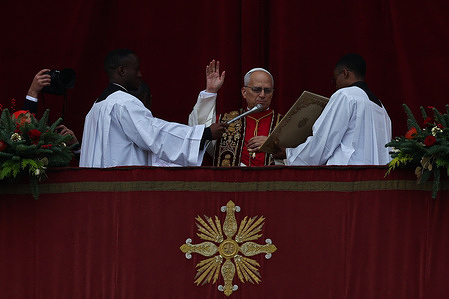 Pope Leo XIV seen bestowing the Urbi et Orbi blessing from the balcony of the central loggia of St. Peter's after presiding over his first Christmas Mass inside the basilica before thousands of faithful.