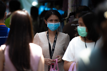 Pedestrians wear protective masks as a protective measure against Coronavirus in Bangkok.