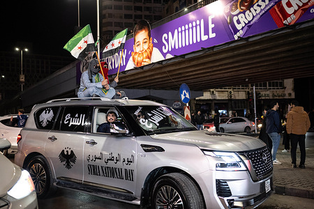 Syrians wave flags and drive around the streets of Damascus in celebration of the first year since the fall of the Assad regime.