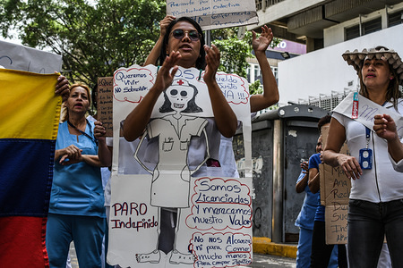 A nurse seen holding a placard during a protest calling for higher salaries and more supplies. 
Medical staff from public hospitals demonstrated in the streets after 30 consecutive days of protest in Caracas to demand an increase in their salaries and supplies to be able to treat patients in hospitals. They are also demanding the same salaries as the military in Venezuela, A soldier currently earns around 240,000,000 million Bsf monthly (69 $) while medical staff in public hospitals earn 3,000,000 bsf ($ 0.90) per month.