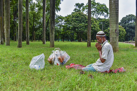 A Muslim park tea vendor is seen praying inside the Suhrawardy Udaan park in Dhaka.