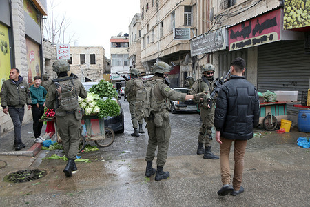 Israeli soldiers speak with a Palestinian youth during a security operation in the market area of ​​the Old City of Nablus in the West Bank. Israeli forces raided the market area and the home of Rami Hasiba and his son Ahmed, in the al-Karmel neighborhood of Nablus.